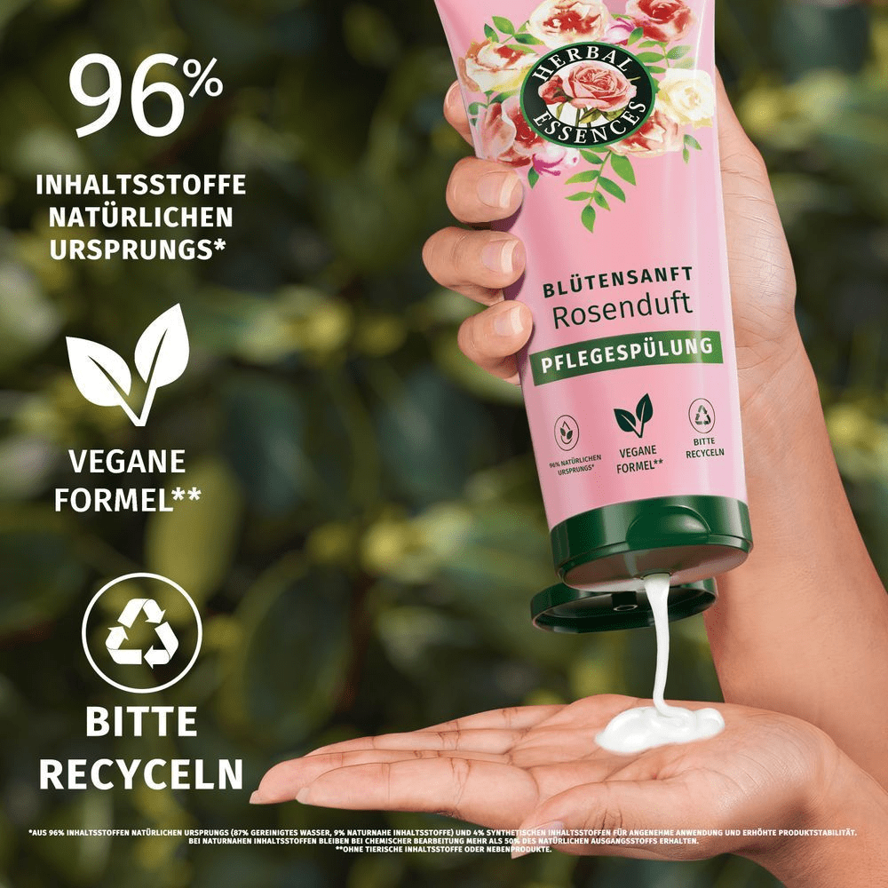Herbal Essences Pflegespülung mit Rosenduft wird in der Hand gehalten, um die cremige Textur und die vegane Formel hervorzuheben.