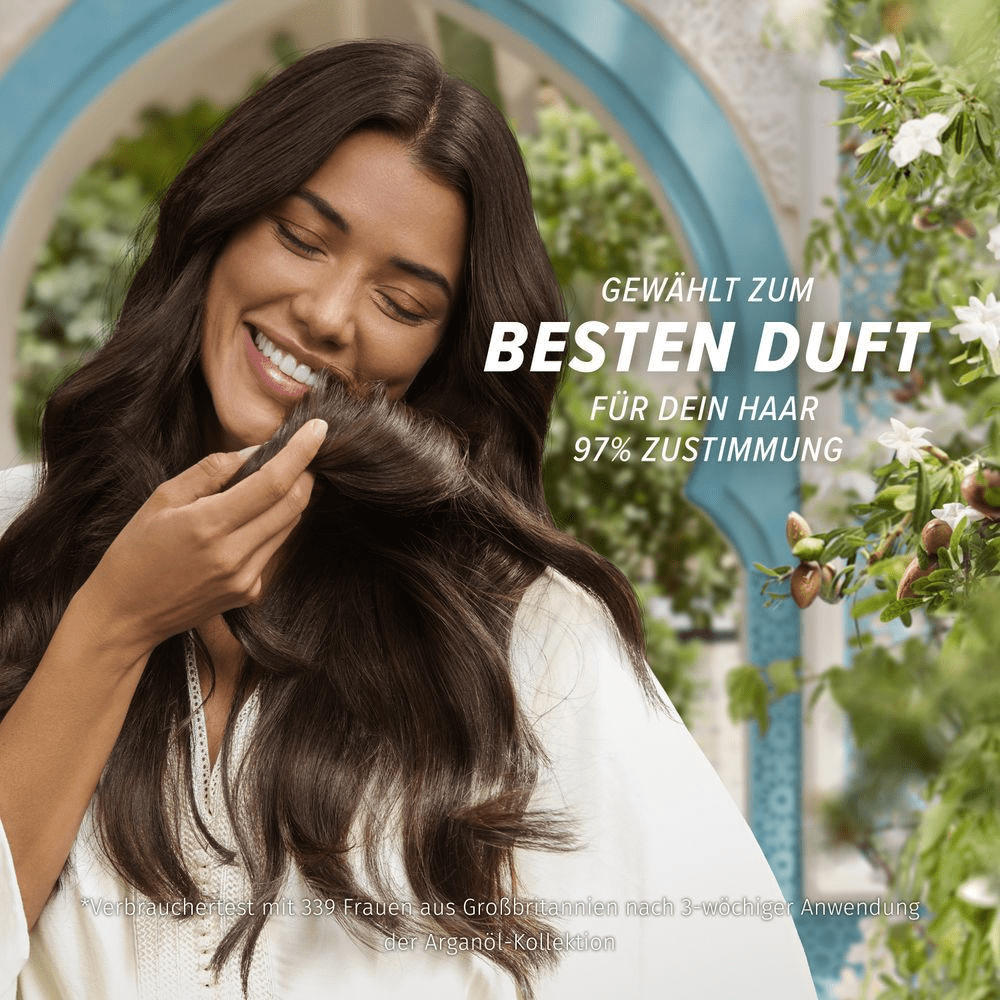 Eine lächelnde Frau genießt den Duft ihres gesunden Haares, hervorgehoben als Bester Duft für dein Haar mit 97% Zustimmung.
