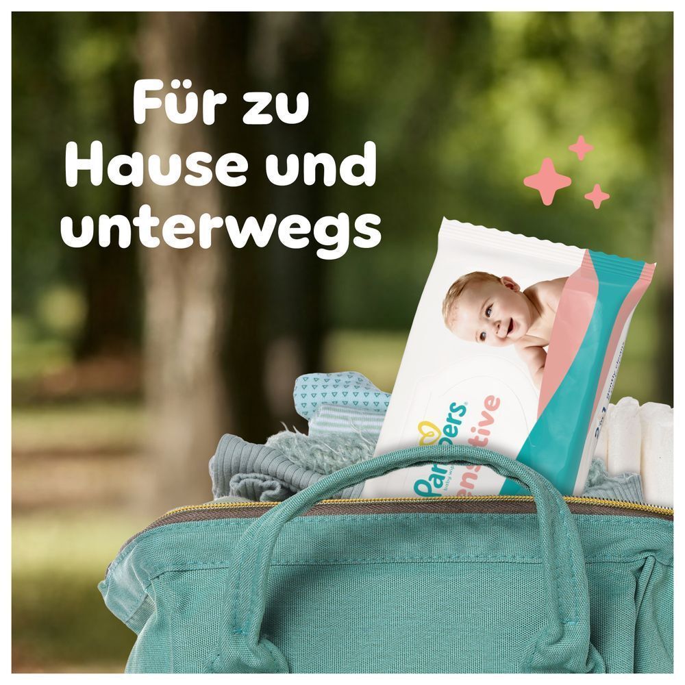 Pampers Sensitive Feuchttücher-Packung in einer Tasche, beworben für Für zu Hause und unterwegs.