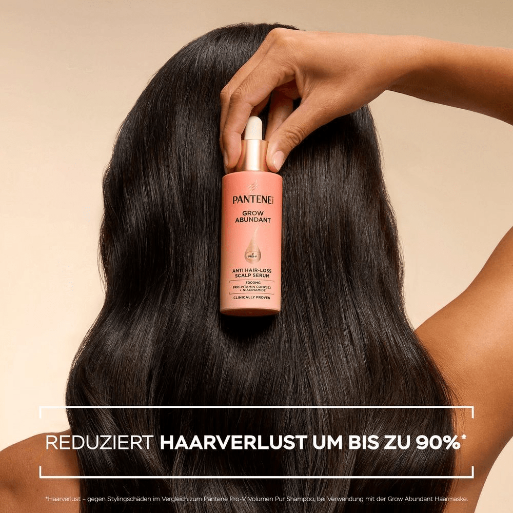 Eine Frau mit langem, glänzendem, dunklem Haar, von hinten gesehen, hält eine Pantene Pro-V Grow Abundant Anti-Haarverlust Kopfhautserumflasche vor ihrem Kopf. Der Hintergrund ist beige. Am unteren Bildrand ist ein weißer Kasten mit schwarzer Schrift zu sehen: VERRINGERT HAARVERLUST UM 90%*.