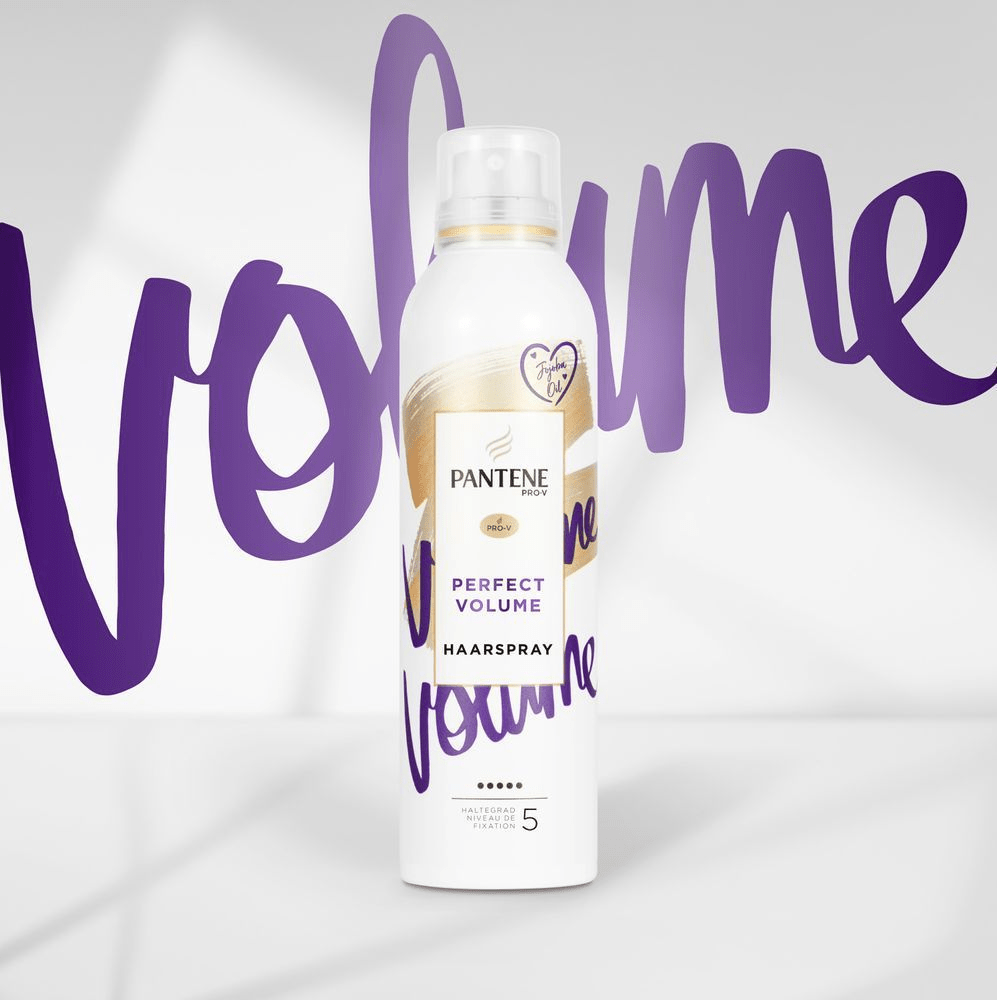Dose Pantene Pro-V Perfect Volume Haarspray mit lila „Volume“-Schriftzug im Hintergrund, Haltegrad 5.