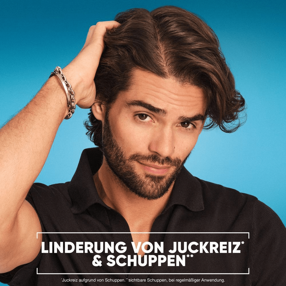 Mann mit dunklem Haar wirbt für Mittel gegen Juckreiz und Schuppen auf blauem Hintergrund.