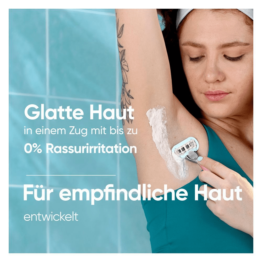 Person trägt Rasierschaum auf und benutzt einen Rasierer für empfindliche Haut mit der Auslobung „0 % Hautreizung“, blaugrüner Hintergrund.