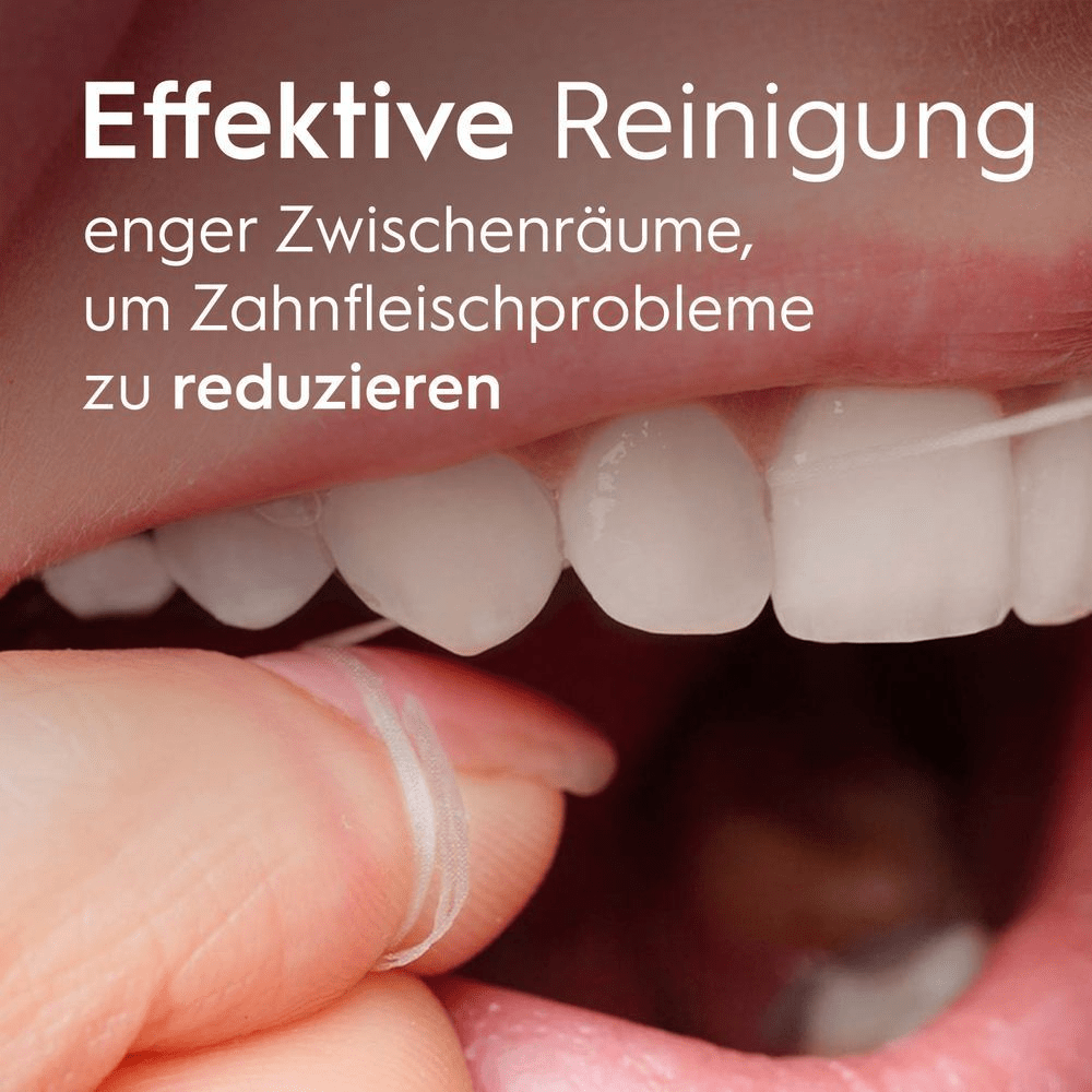 Nahaufnahme eines Mundes, der mit Zahnseide gereinigt wird, wobei Zähne und Finger zu sehen sind.