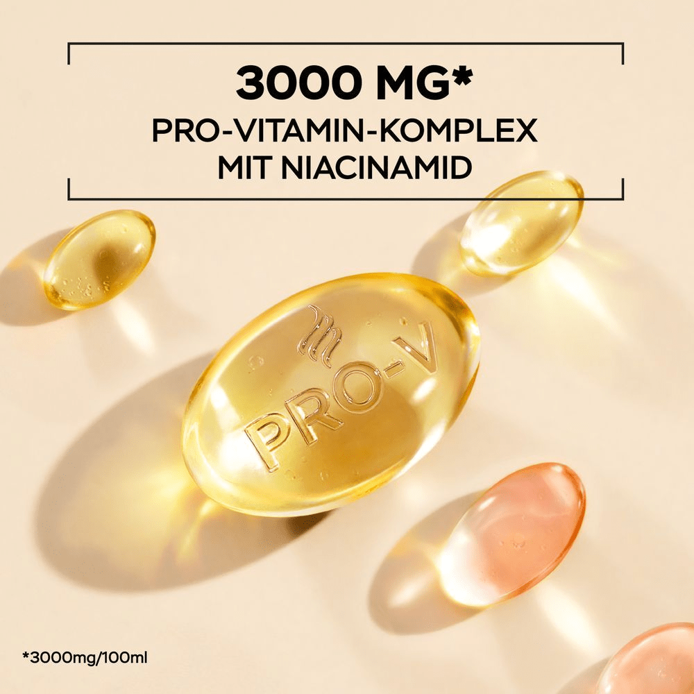 Mehrere goldene, transparente Kapseln, die an Vitamine erinnern, liegen auf einem beigefarbenen Untergrund. Eine der Kapseln ist größer und hat ein 'PRO-V' Logo eingeprägt. Darüber steht in schwarzer Schrift: 3000 MG PRO-VITAMIN-COMPLEX MIT NIACINAMID.