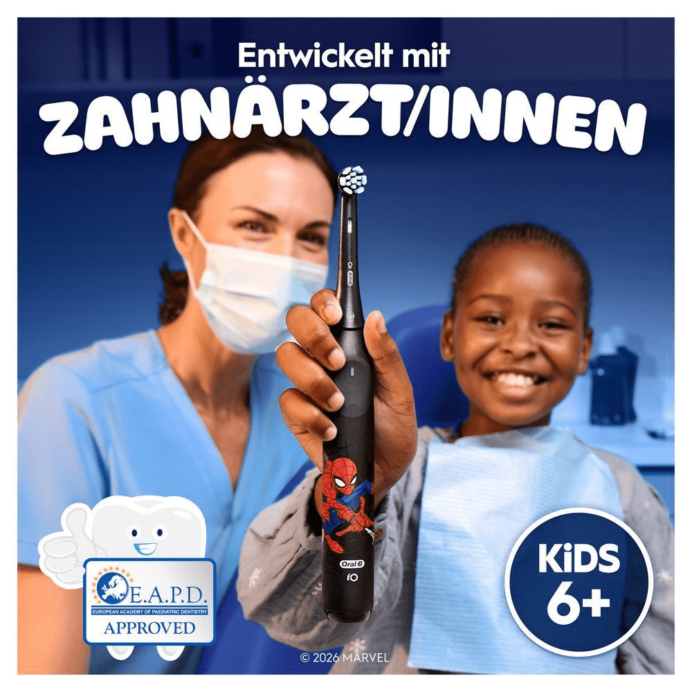 Zahnarzt & Kind im Zahnarztstuhl, das die iO Kids 6+ hält. Text: Entwickelt mit ZahnärztInnen.